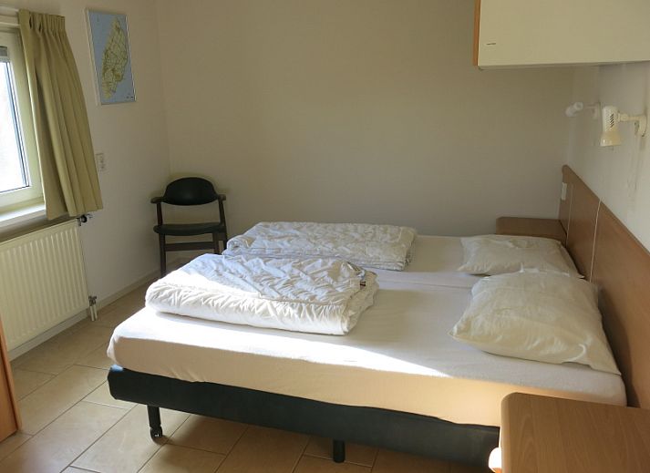 Gezellige woonkamer van Bungalow 't Luwe Land 49 in De Koog Texel, met comfortabele banken en uitzicht op de natuur van de Waddeneilanden.