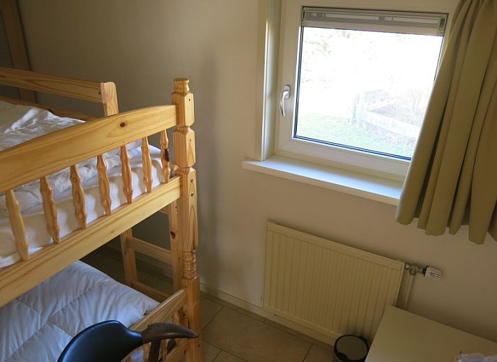 Gezellige woonkamer van Bungalow 't Luwe Land 49 in De Koog Texel, met comfortabele banken en uitzicht op de natuur van de Waddeneilanden.