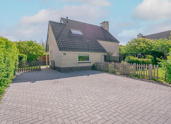 Vakantiehuis Kamperfoelie 81 met sauna in De Koog, Texel, biedt een ruime oprit en groene omgeving voor een ontspannen verblijf.