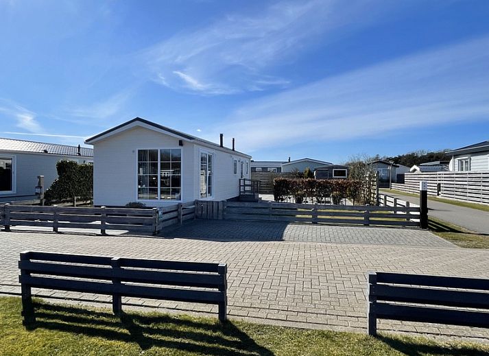 Essecke im Chalet Bregkoog 227, Chaletpark Bregkoog, De Koog, Texel mit bunten Stuehlen und einem stilvollen Tisch.