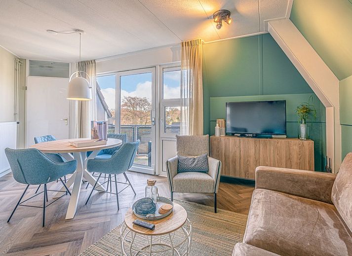 Gezellige woonkamer in Appartement Zeedistel 22, De Koog, Texel met comfortabel meubilair en uitzicht op de Waddeneilanden.