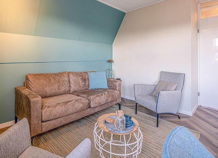 Gezellige woonkamer in Appartement Zeedistel 22, De Koog, Texel met comfortabel meubilair en uitzicht op de Waddeneilanden.