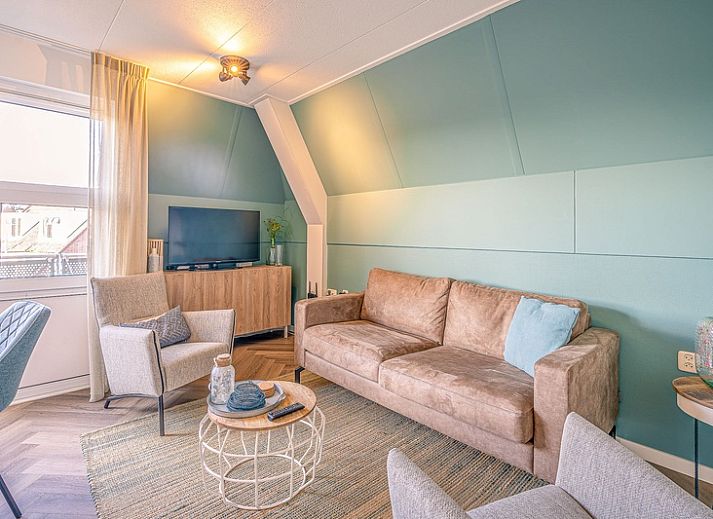 Gezellige woonkamer in Appartement Zeedistel 22, De Koog, Texel met comfortabel meubilair en uitzicht op de Waddeneilanden.