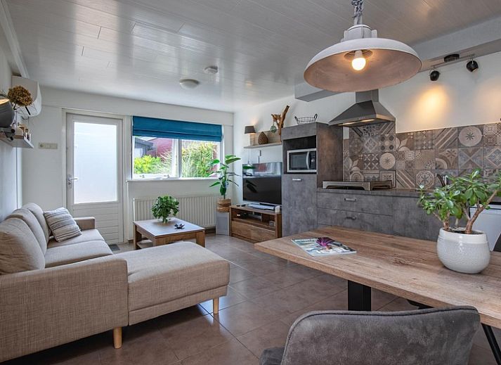 Gezellige woonkamer in Duo bungalow, De Koog, Texel met comfortabele bank en veel natuurlijk licht.