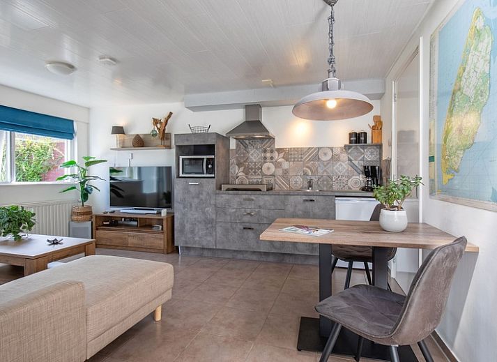 Gezellige woonkamer in Duo bungalow, De Koog, Texel met comfortabele bank en veel natuurlijk licht.