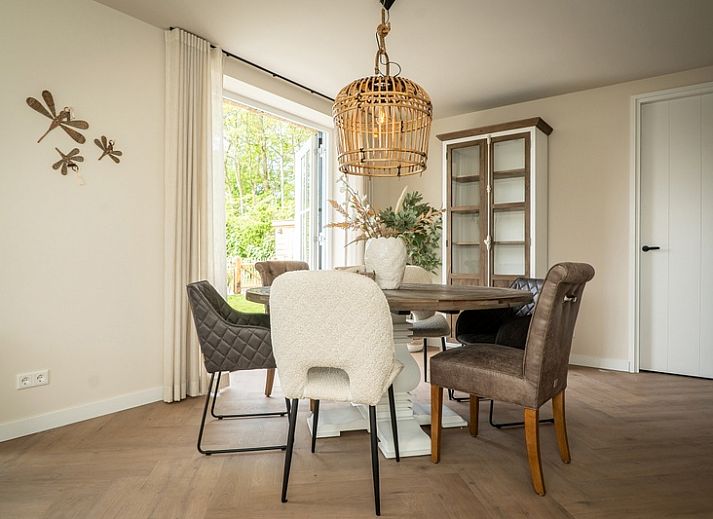 Seitenansicht der Villa 25b, Ferienhaus in De Koog, Texel mit moderner Terrasse und gruener Umgebung.