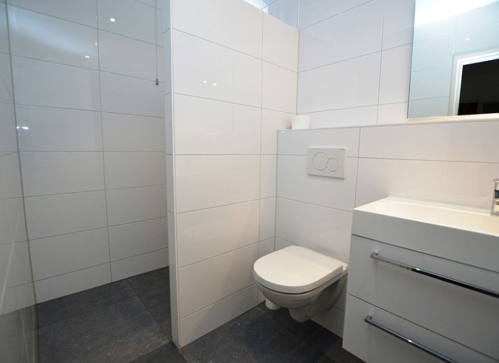 Gemuetliches Wohnzimmer des Ferienhauses Epelaan 31 in De Koog, Texel, mit Blick auf den Garten.