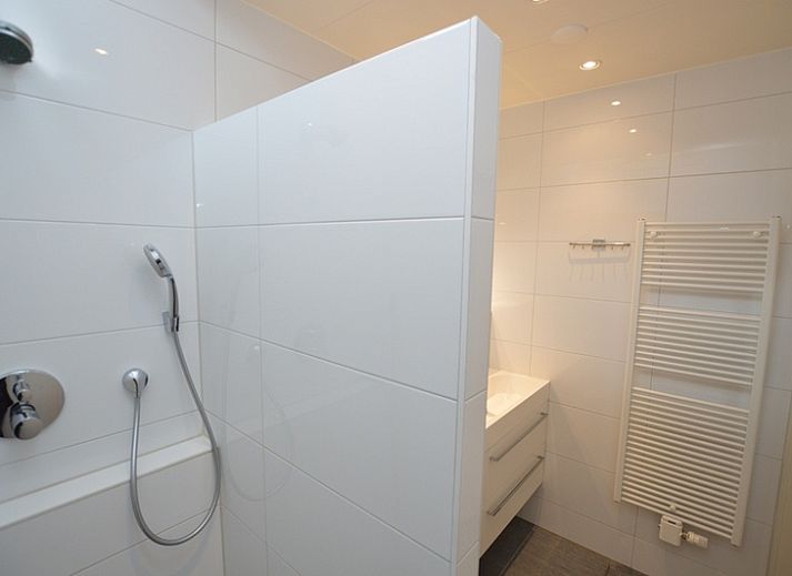 Gemuetliches Wohnzimmer des Ferienhauses Epelaan 31 in De Koog, Texel, mit Blick auf den Garten.