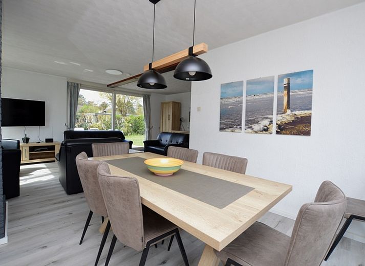 Gezellige woonkamer in Orchismient 33, De Koog, Texel met uitzicht op de groene tuin.