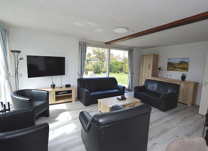 Gezellige woonkamer in Orchismient 33, De Koog, Texel met uitzicht op de groene tuin.