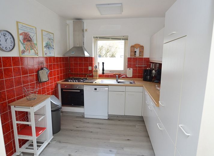 Gezellige woonkamer in Orchismient 33, De Koog, Texel met uitzicht op de groene tuin.