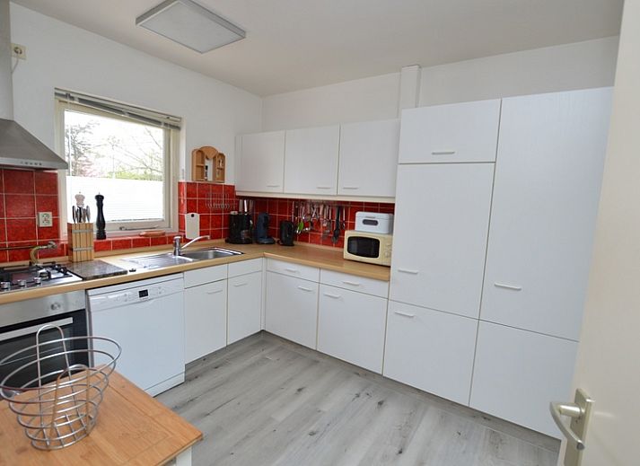 Gezellige woonkamer in Orchismient 33, De Koog, Texel met uitzicht op de groene tuin.