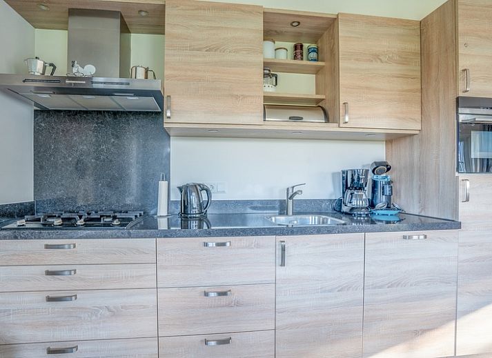 Gezellige woonkamer van vakantiehuis Maaikeduinweg 13 in De Koog, Texel met comfortabele zithoek en uitzicht op de tuin.