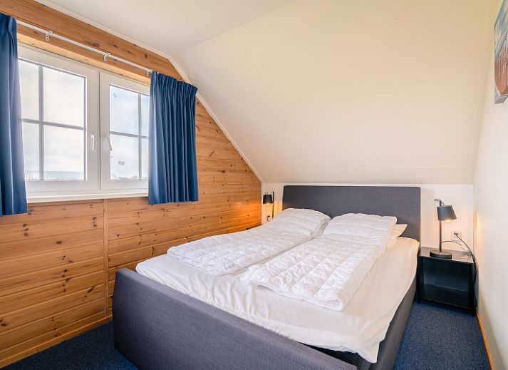 Gezellige woonkamer van vakantiehuis Maaikeduinweg 13 in De Koog, Texel met comfortabele zithoek en uitzicht op de tuin.