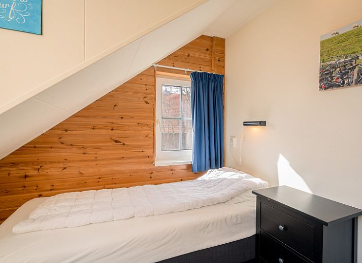 Moderne woonkamer in vakantiehuis Maaikeduinweg 13, De Koog, Texel, met flatscreen-tv en sfeervolle inrichting op de Waddeneilanden.