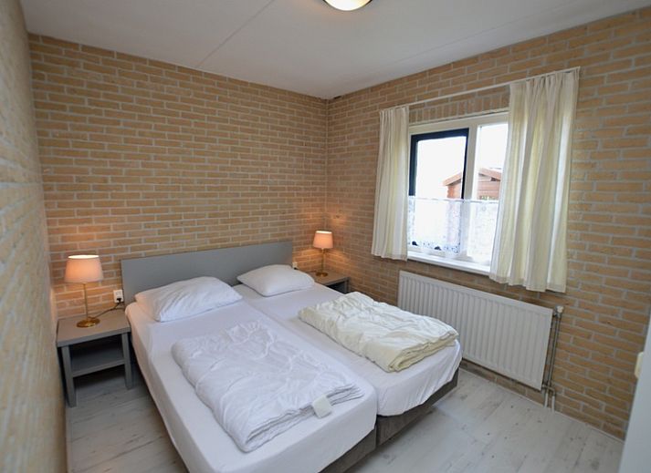 Gemuetliches Wohnzimmer im Ferienhaus Stappeland 207, De Koog, Texel mit bequemen Sofas und einem Kamin.