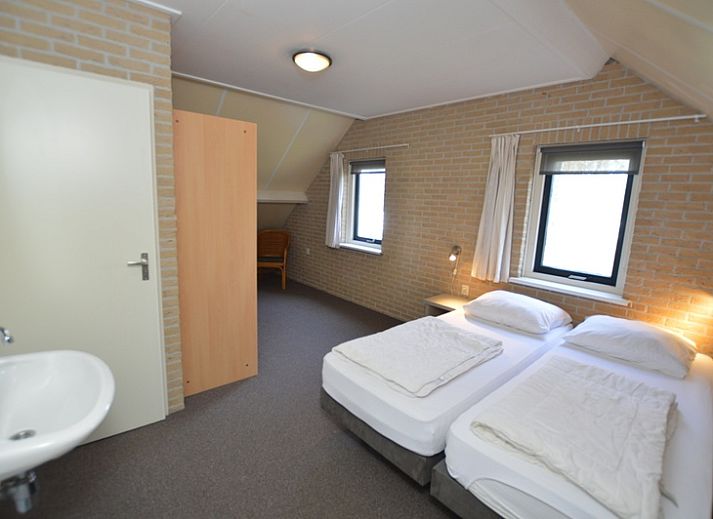 Geraeumiger Wohnraum im Ferienhaus Stappeland 207, De Koog, Texel mit offener Kueche und Sitzecke.