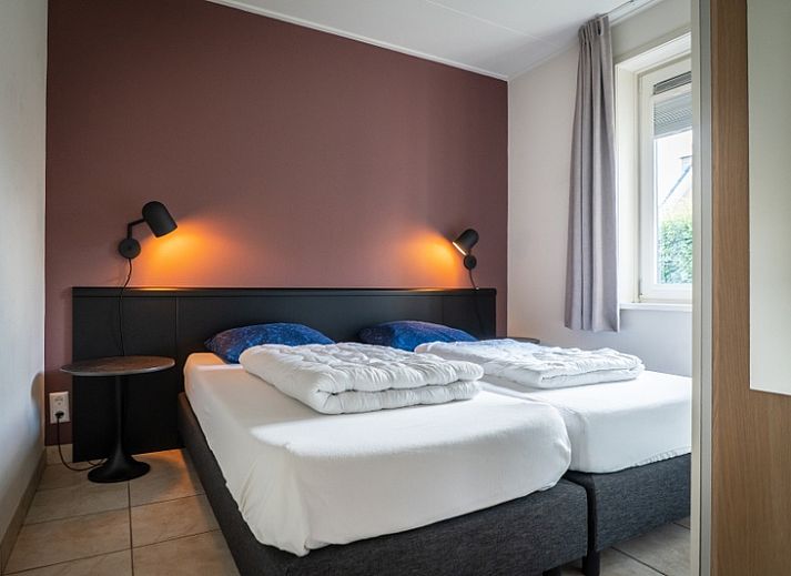 Gezellige woonkamer in Bungalow 15a, De Koog, Texel, met open haard en comfortabele zitruimte voor ontspanning.