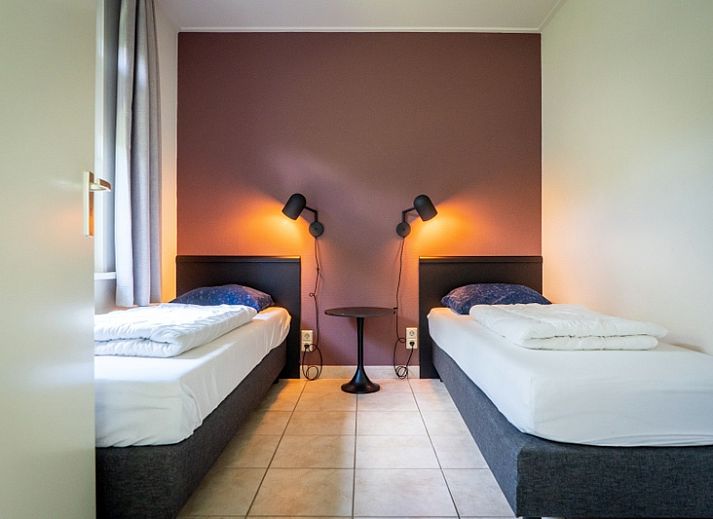 Gezellige woonkamer in Bungalow 15a, De Koog, Texel, met open haard en comfortabele zitruimte voor ontspanning.