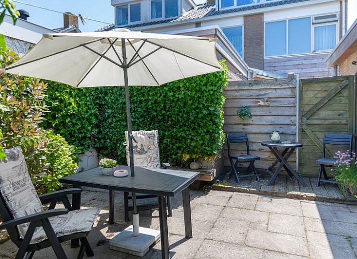 Zonnig terras van Bungalow 9708 in De Koog, Texel met gezellige zithoek en parasol.