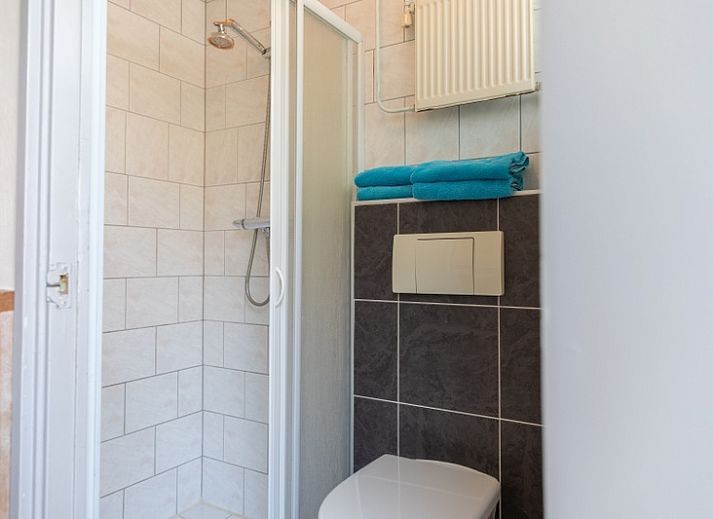 Zonnig terras van Bungalow 9708 in De Koog, Texel met gezellige zithoek en parasol.