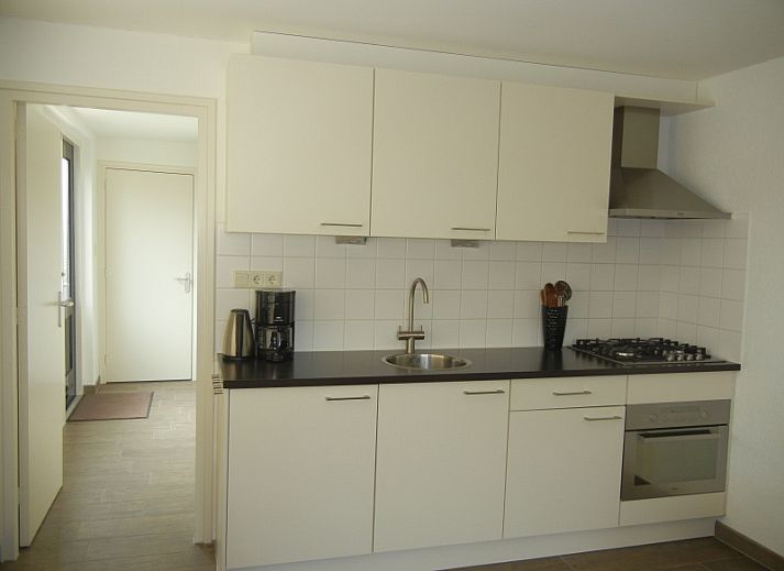 Gemuetliches Wohnzimmer im Ferienhaus 1, De Koog, Texel mit bequemen Sofas und einer Essecke.