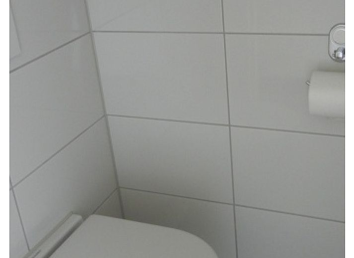 Gemuetliches Wohnzimmer im Ferienhaus 1, De Koog, Texel mit bequemen Sofas und einer Essecke.