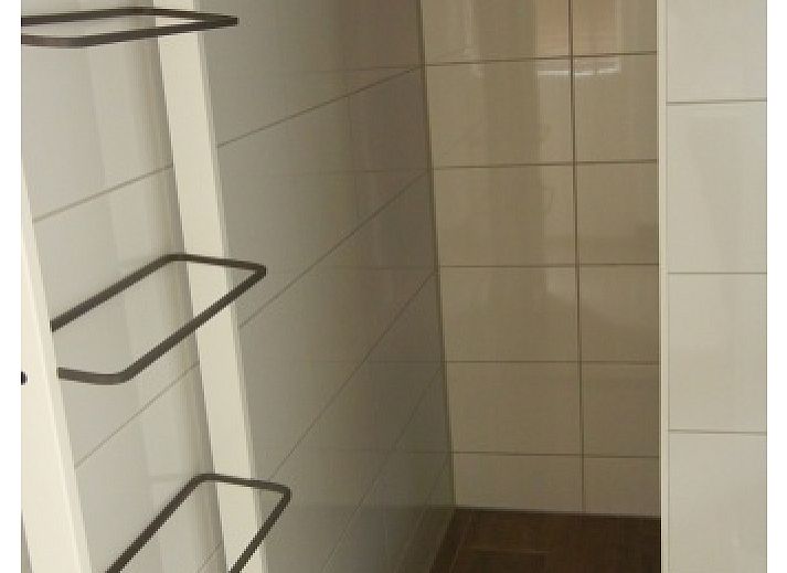 Aussenansicht des Ferienhauses 1, De Koog, Texel mit sonniger Fassade und grossen Fenstern.