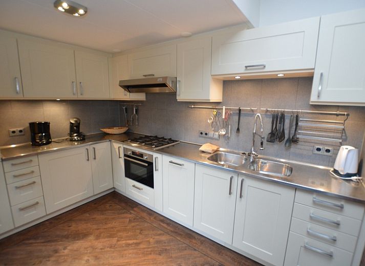 Ingang van Orchismient 28 in De Koog Texel met bakstenen muren en glazen deur.