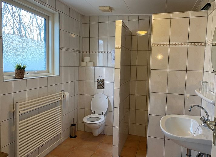 Terrasse des Bungalows 51 in 't Luwe Land, De Koog, Texel, mit Gartenmoebeln und gruener Umgebung.