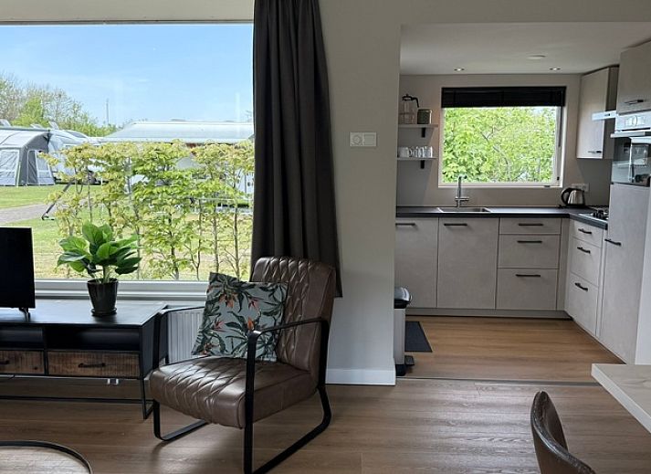 Gezellige woonkamer van vakantiehuis Huisje Boszicht in De Koog, Texel, met veel natuurlijk licht en uitzicht op de omliggende natuur.