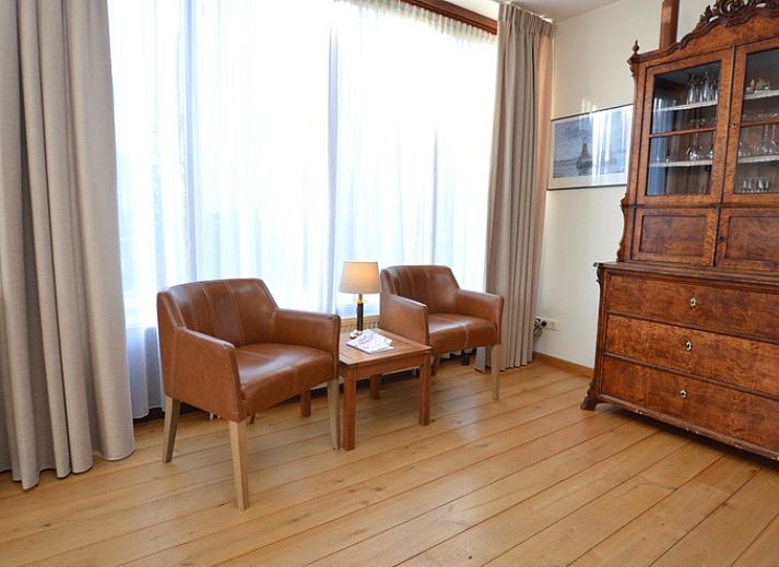 Ruime eetkamer in vakantiehuis Orchismient 35, De Koog, Texel, met houten meubels.