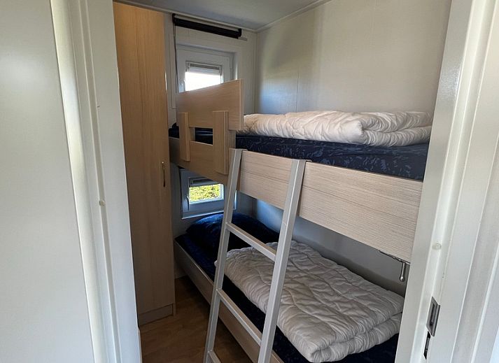 Chalet type 3 in De Koog, Texel biedt een prachtig uitzicht op de groene omgeving en speeltuin, ideaal voor een ontspannen vakantie.