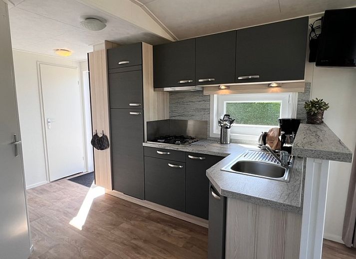 Chalet type 3 in De Koog, Texel biedt een prachtig uitzicht op de groene omgeving en speeltuin, ideaal voor een ontspannen vakantie.