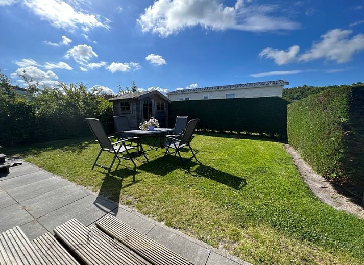 Chalet type 3 in De Koog, Texel biedt een prachtig uitzicht op de groene omgeving en speeltuin, ideaal voor een ontspannen vakantie.