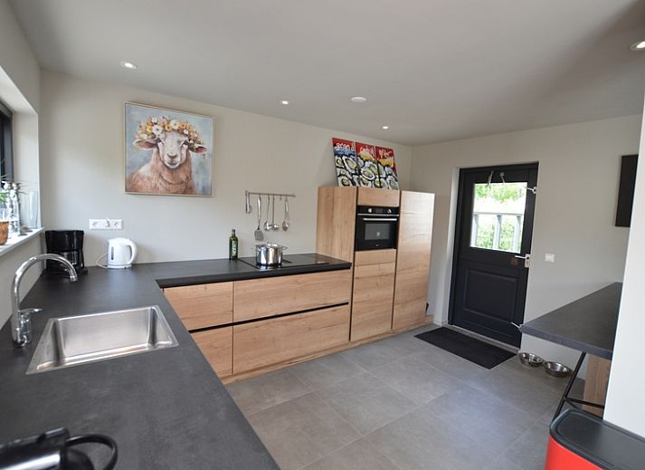 Gezellige woonkamer van Ruijslaan 73 in De Koog Texel met comfortabele banken en uitzicht op de natuur.