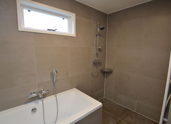 Gezellige woonkamer van Vakantiehuis Stappeland 111 in De Koog, Texel met comfortabele zithoek en open haard.