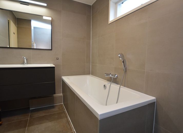 Gezellige woonkamer van Vakantiehuis Stappeland 111 in De Koog, Texel met comfortabele zithoek en open haard.