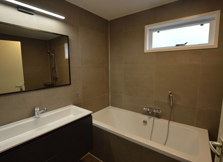 Gezellige woonkamer van Vakantiehuis Stappeland 111 in De Koog, Texel met comfortabele zithoek en open haard.