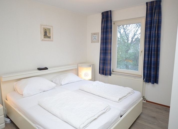 Gezellige woonkamer van Vakantiehuis Stappeland 111 in De Koog, Texel met comfortabele zithoek en open haard.