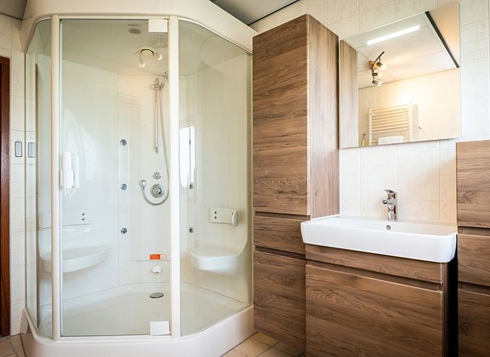 Comfortabele zithoek in Villa met Serre, vakantiehuis in De Koog, Texel met uitzicht op de groene omgeving.