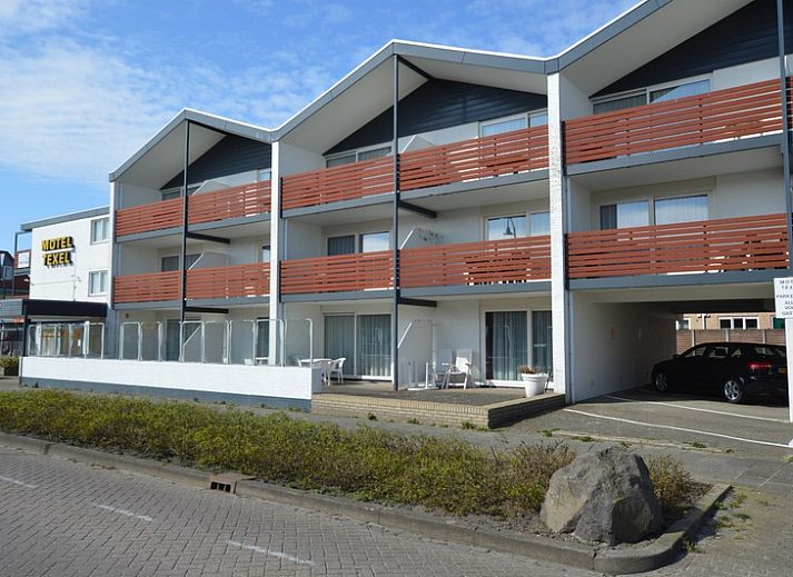 Ruime woonkamer met toegang tot het balkon in Motel Texel - Appartement 208/1L, De Koog, Texel. Perfect voor een vakantie op de Waddeneilanden.