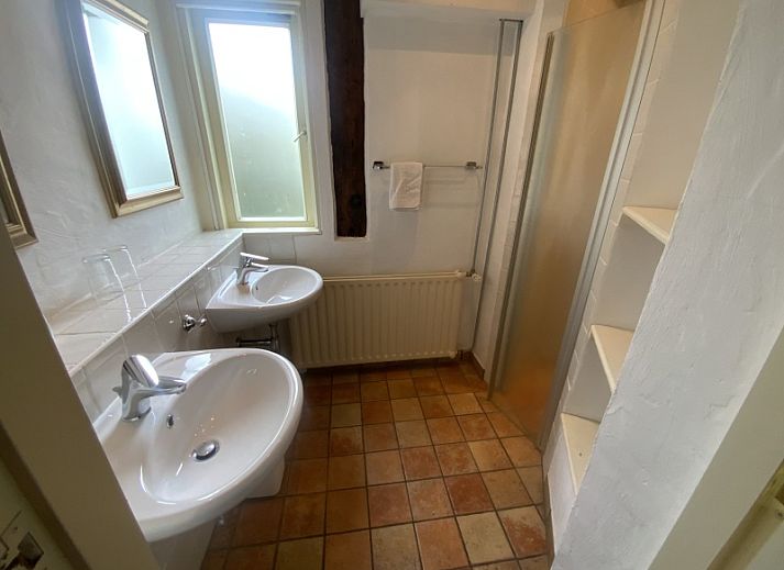 Gezellig terras bij Voorhuis vakantiewoning in De Koog, Texel omringd door groene natuur.