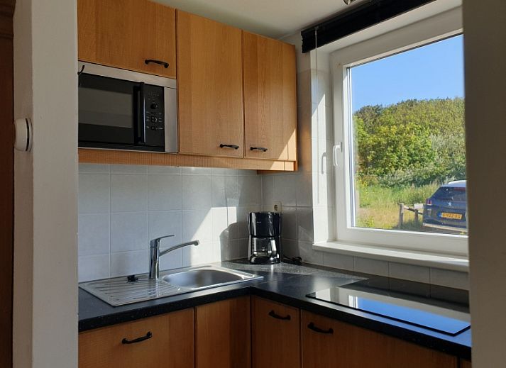 Gemuetliche Terrasse von De Duinpan - Duinhuisje Texel in De Koog, Texel, mit bequemen Sitzgelegenheiten.