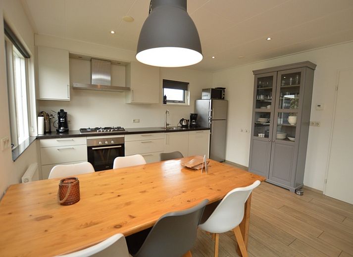 Gemuetliches Wohnzimmer des Ferienhauses Stappeland 215 in De Koog, Texel, mit bequemer Sitzecke und Gartenblick.