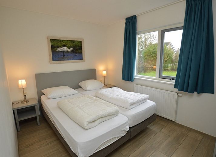 Gemuetliches Wohnzimmer des Ferienhauses Stappeland 215 in De Koog, Texel, mit bequemer Sitzecke und Gartenblick.