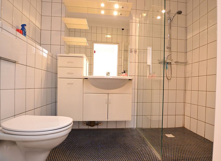 Lichte woonkamer van Appartement Kerckeland 98, De Koog, Texel met grote ramen en moderne meubels.