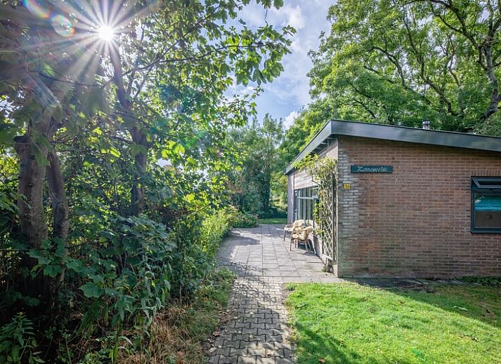 De Zonneweelde vakantiehuis in De Koog, Texel omgeven door groene natuur en zonlicht.