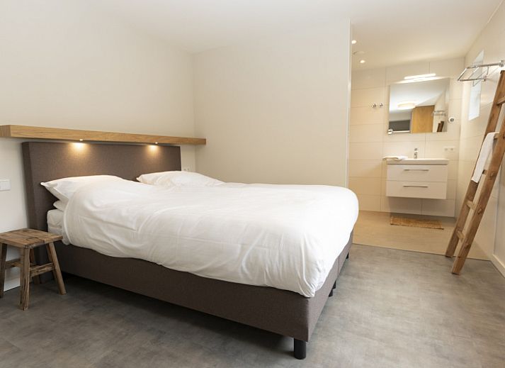 Comfortabele woonkamer in Buitenduin vakantiehuis op Texel, met ruime zithoek en boekenplank.