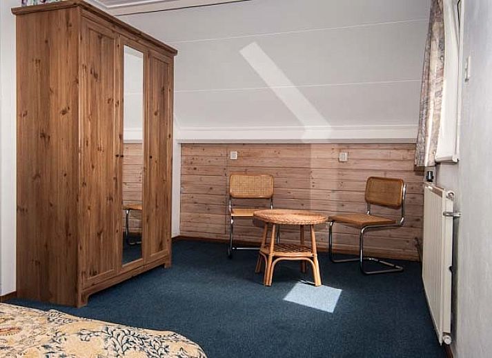 Gezellige woonkamer van De kemphaan: Vakantiehuis Texel in De Koog, met comfortabele zitruimte en houtkachel.